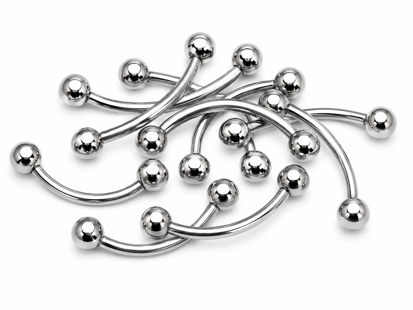 A pile of curved stainless steel labret barbell jewelry with polished ball end tips, arranged on a clean white background.
