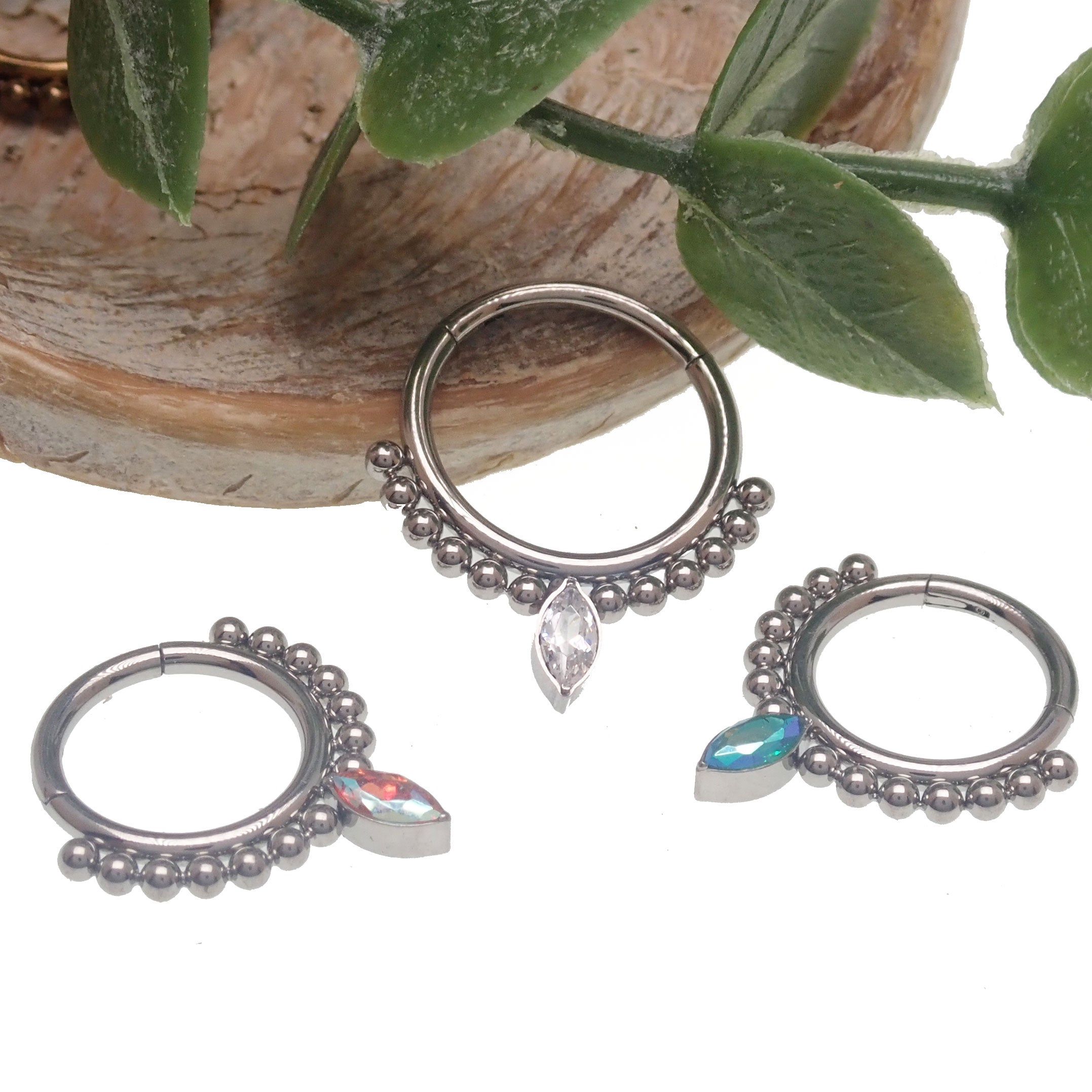 Beaded titanium teardrop clicker ring 16g body jewelry with intricate bead details and smooth curved design.