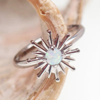 Implant grade titanium white opal sun hinge clicker body jewelry in 16g with 8mm or 10mm diameter for ear or body piercing.