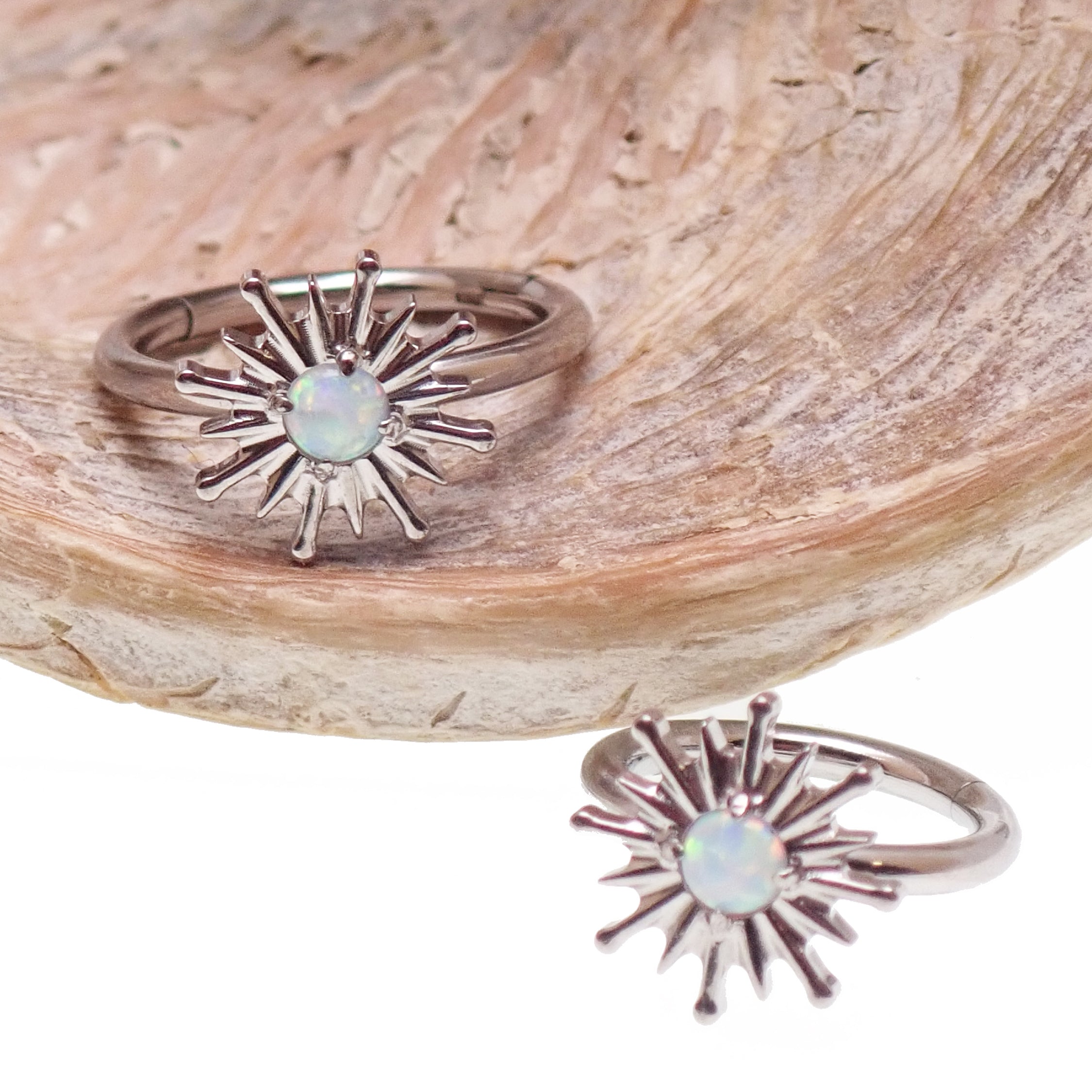 Implant grade titanium white opal sun hinge clicker body jewelry in 16g with 8mm or 10mm diameter.